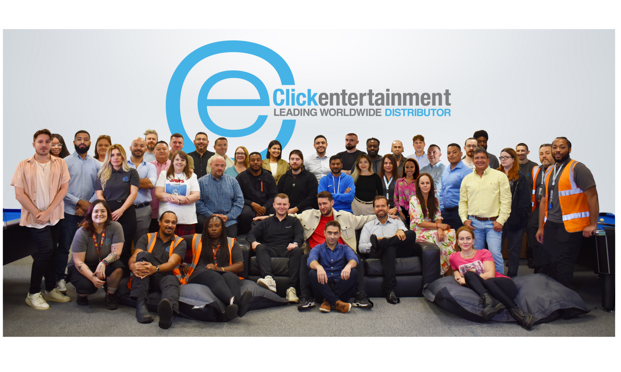around 30 people, all click entertainment epmployees, gathered in front of a white wall.